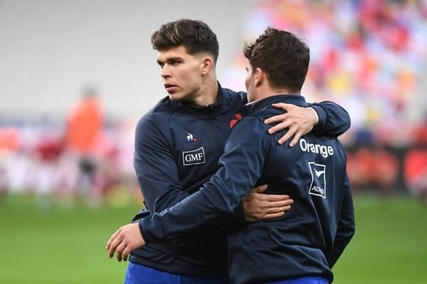 Matthieu Jalibert hugs Antoine Dupont during a France training session